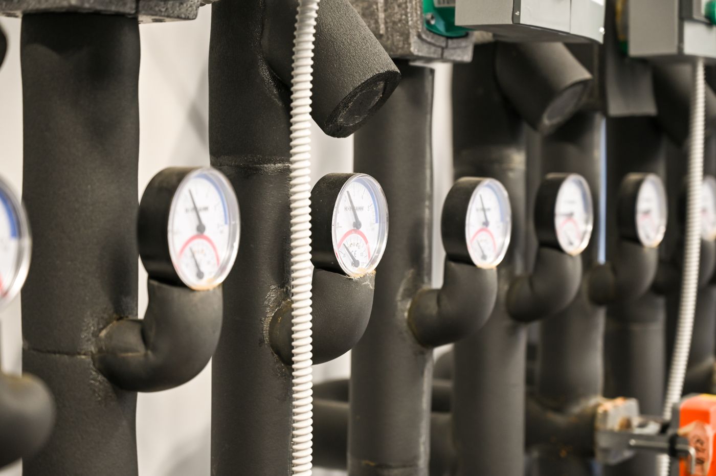 Row of pressure gauges on insulated water pipes